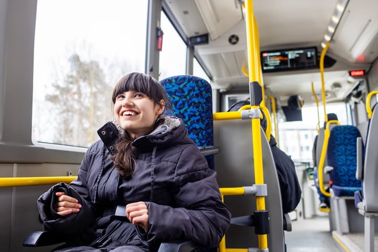 A smiling participant travelling on public transport